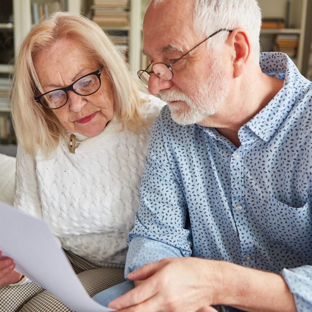 Couple age 60+ reviewing paperwork together