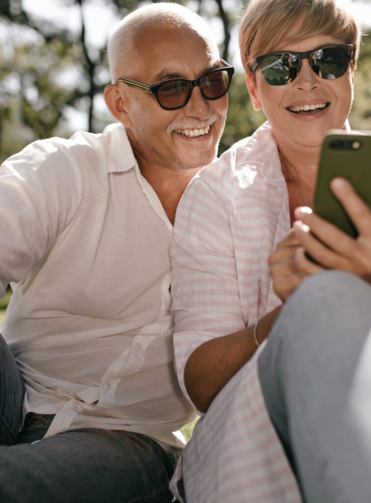 A man and women looking at a phone while smiling